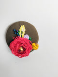 Decorative red flower brooch on olive background