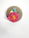Decorative burgundy flower brooch on olive background