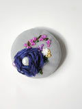 Decorative blue flower brooch on grey background