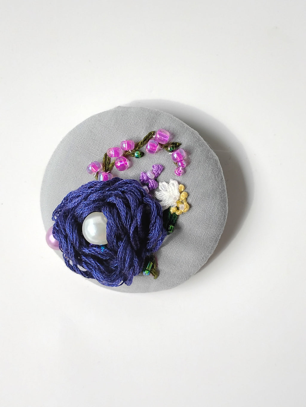 Decorative blue flower brooch on grey background