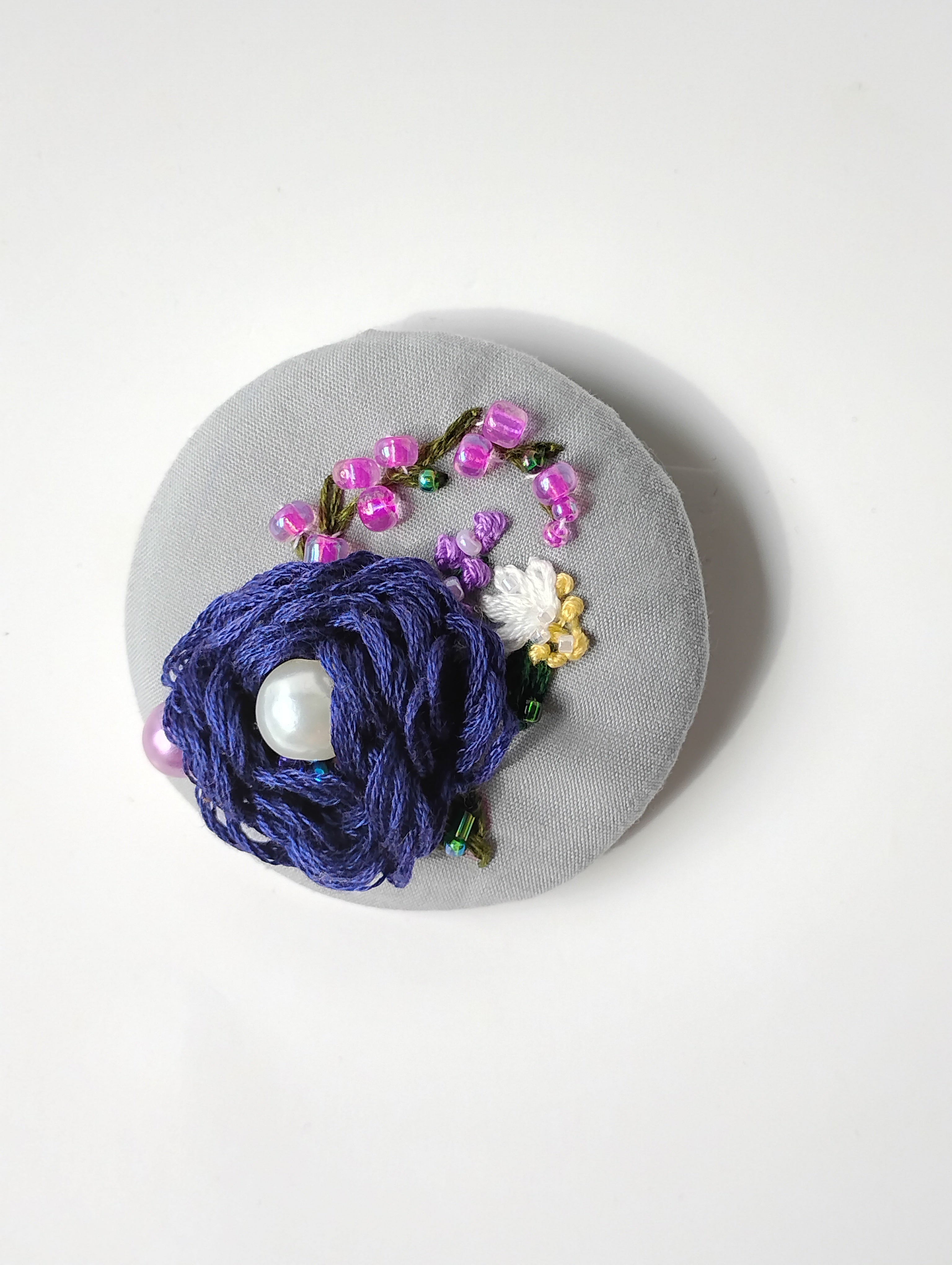 Decorative blue flower brooch on grey background