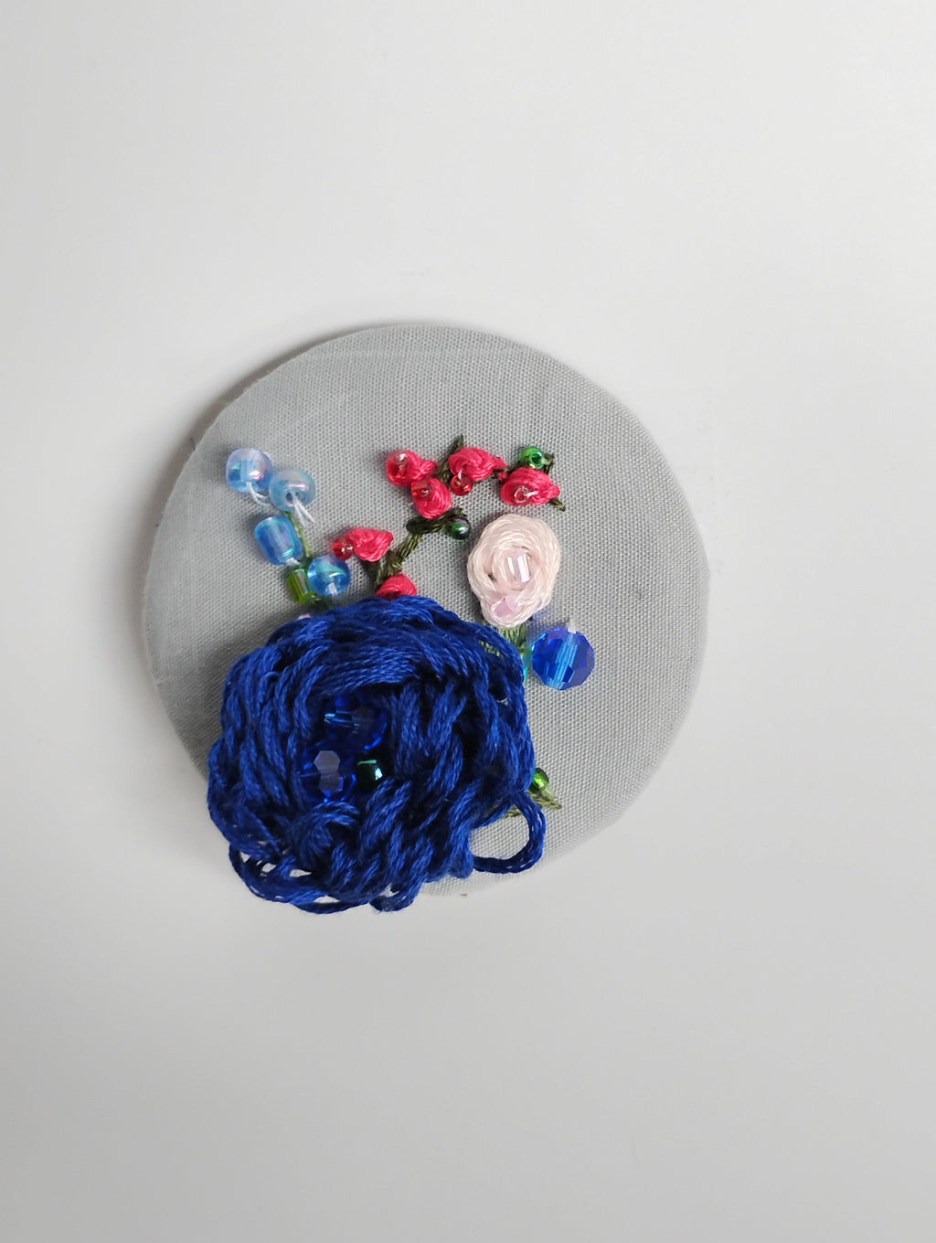 Decorative blue flower brooch on grey background