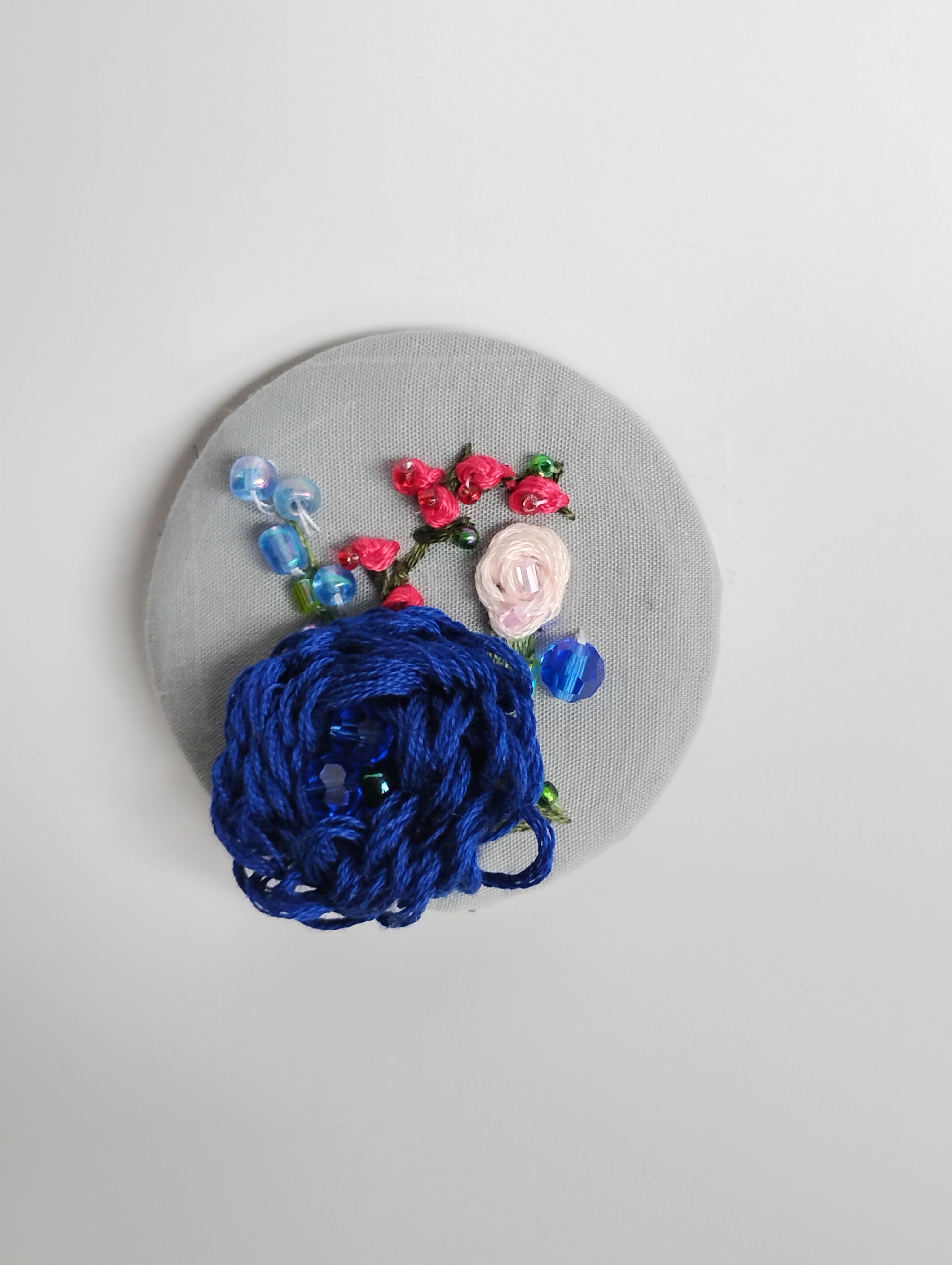 Decorative blue flower brooch on grey background