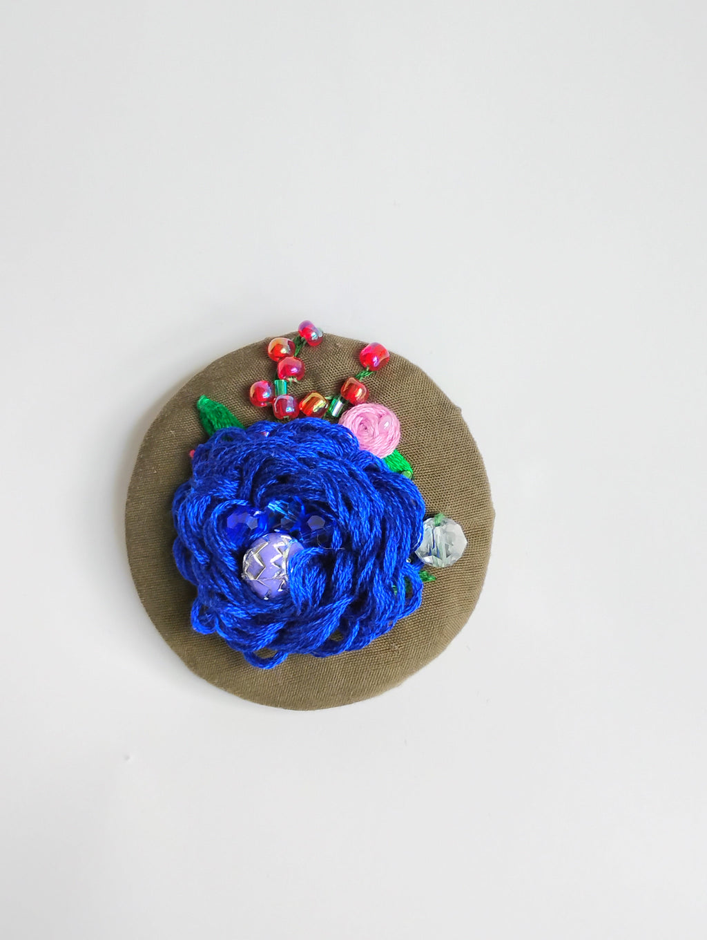 Decorative blue flower brooch on grey background