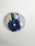 Decorative blue flower brooch on grey background