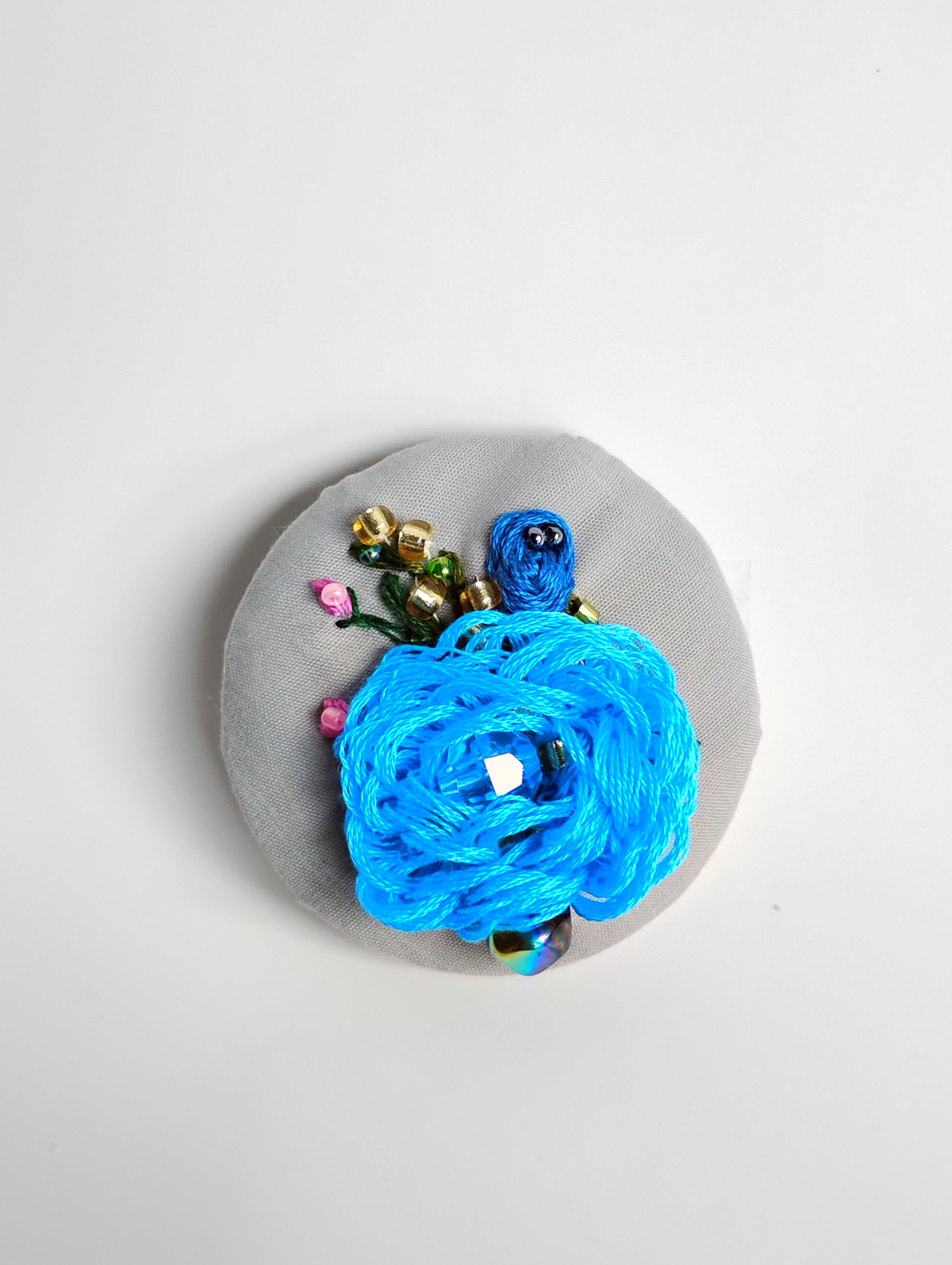 Decorative blue flower brooch on grey background