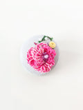 Decorative pink flower brooch on grey background