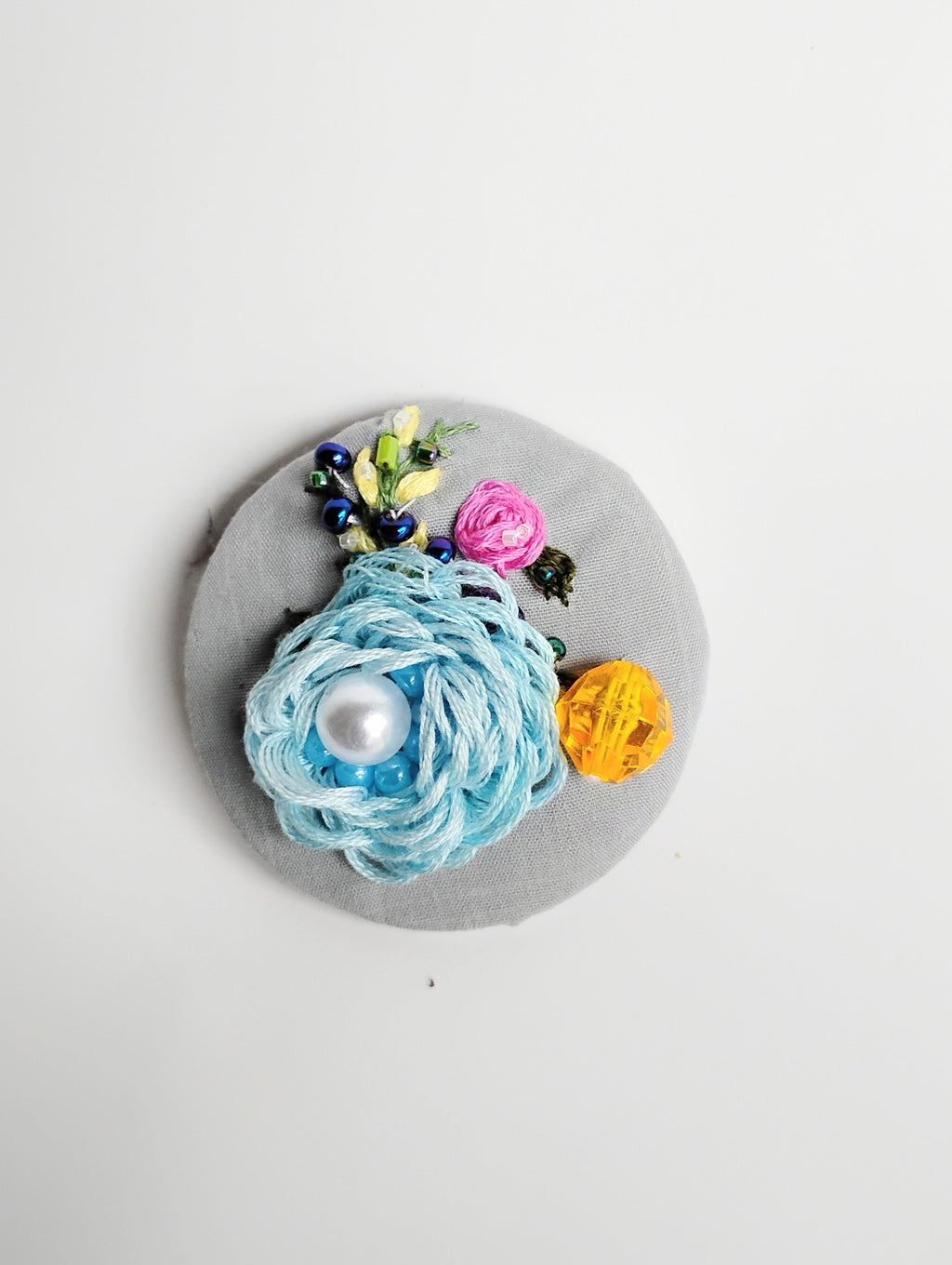 Decorative blue flower brooch on grey background