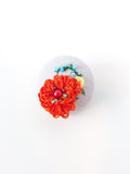 Decorative orange flower brooch on grey background