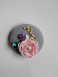 Decorative pink flower brooch on grey background
