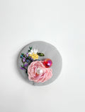 Decorative pink flower brooch on grey background
