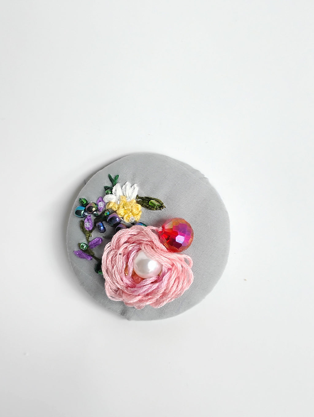 Decorative pink flower brooch on grey background