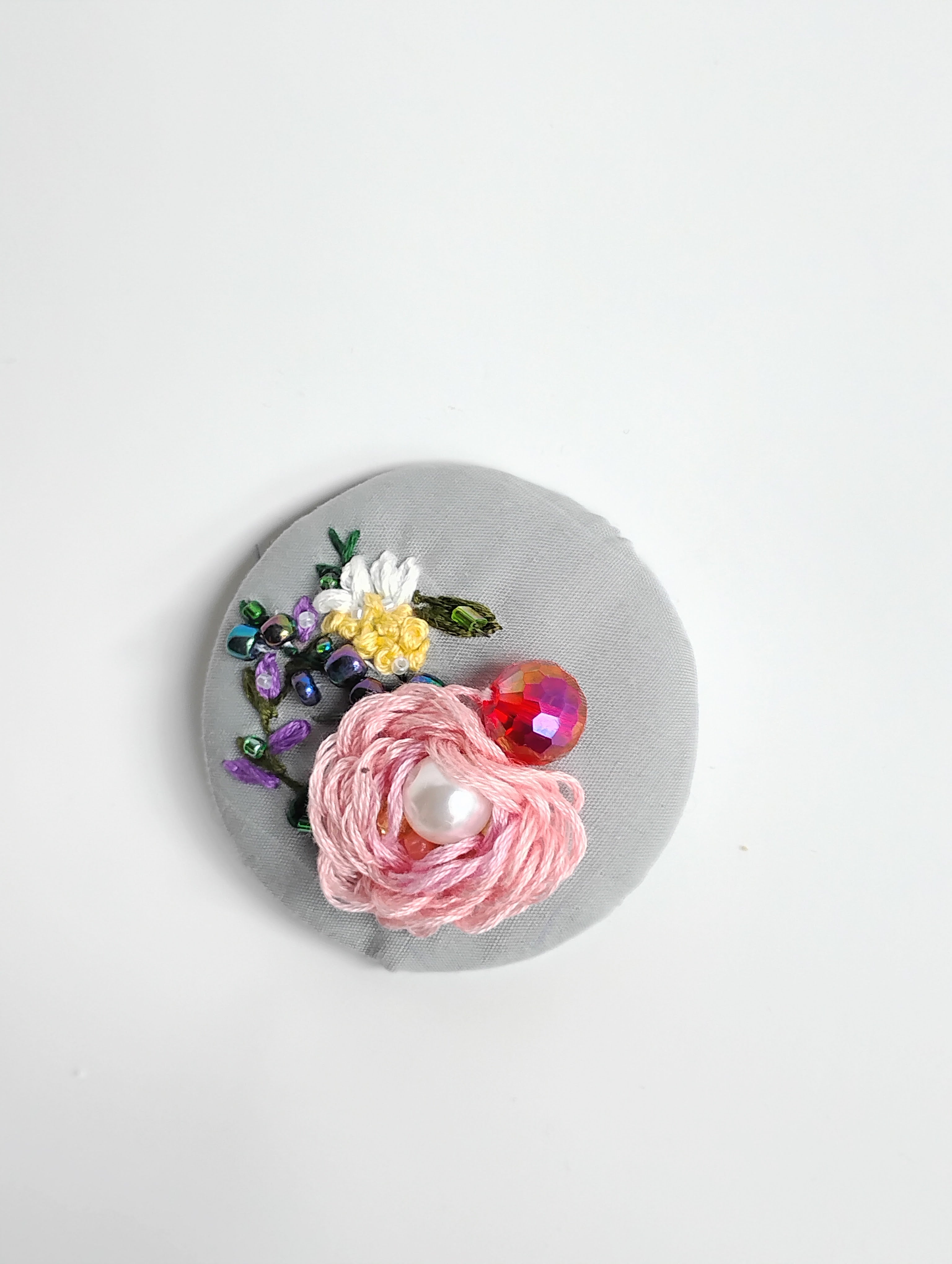 Decorative pink flower brooch on grey background