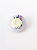 Decorative yellow flower brooch on grey background