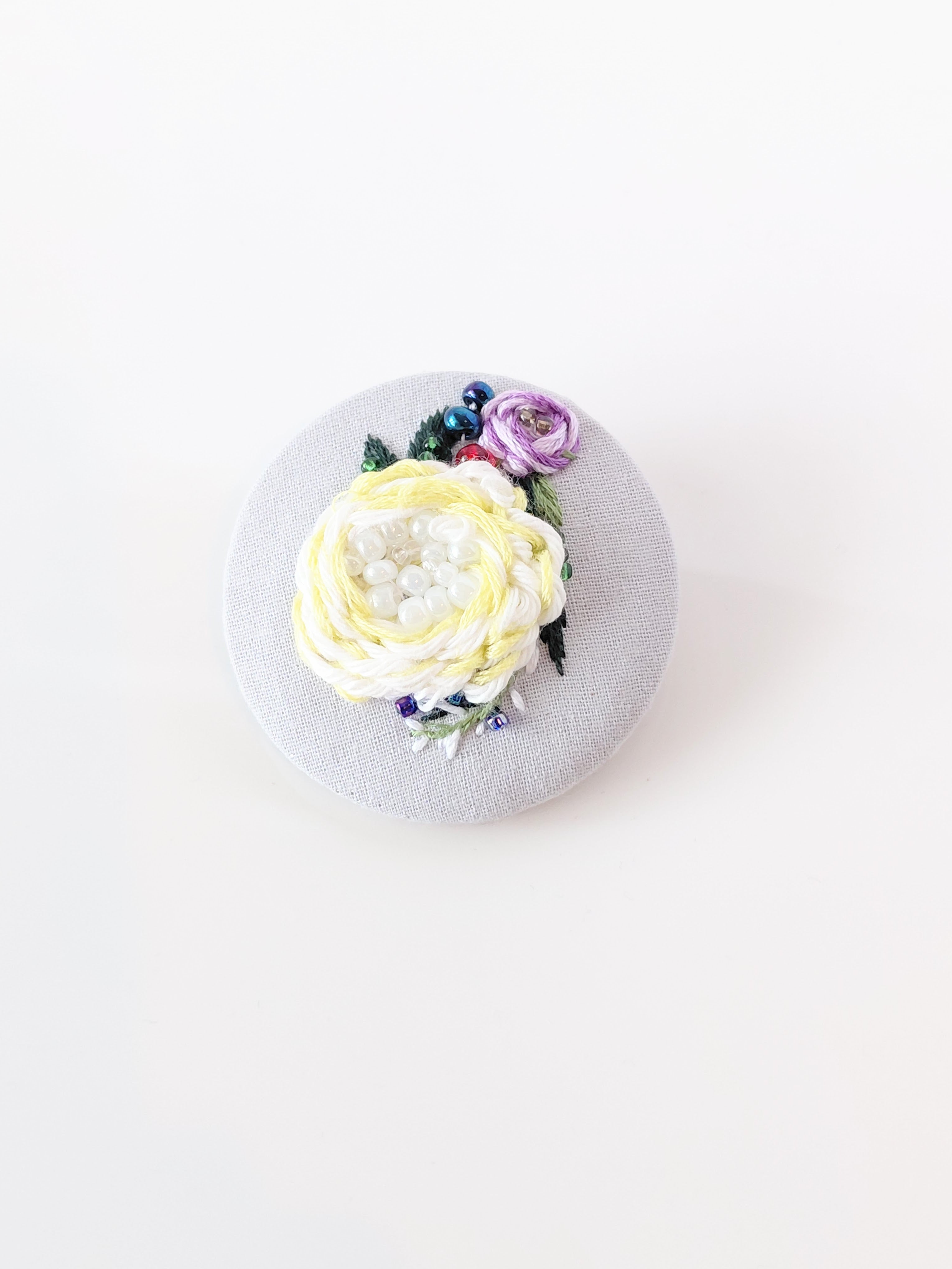 Decorative yellow flower brooch on grey background