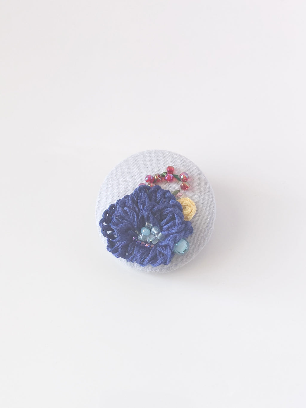 Decorative blue flower brooch on grey background