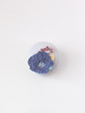 Decorative blue flower brooch on grey background