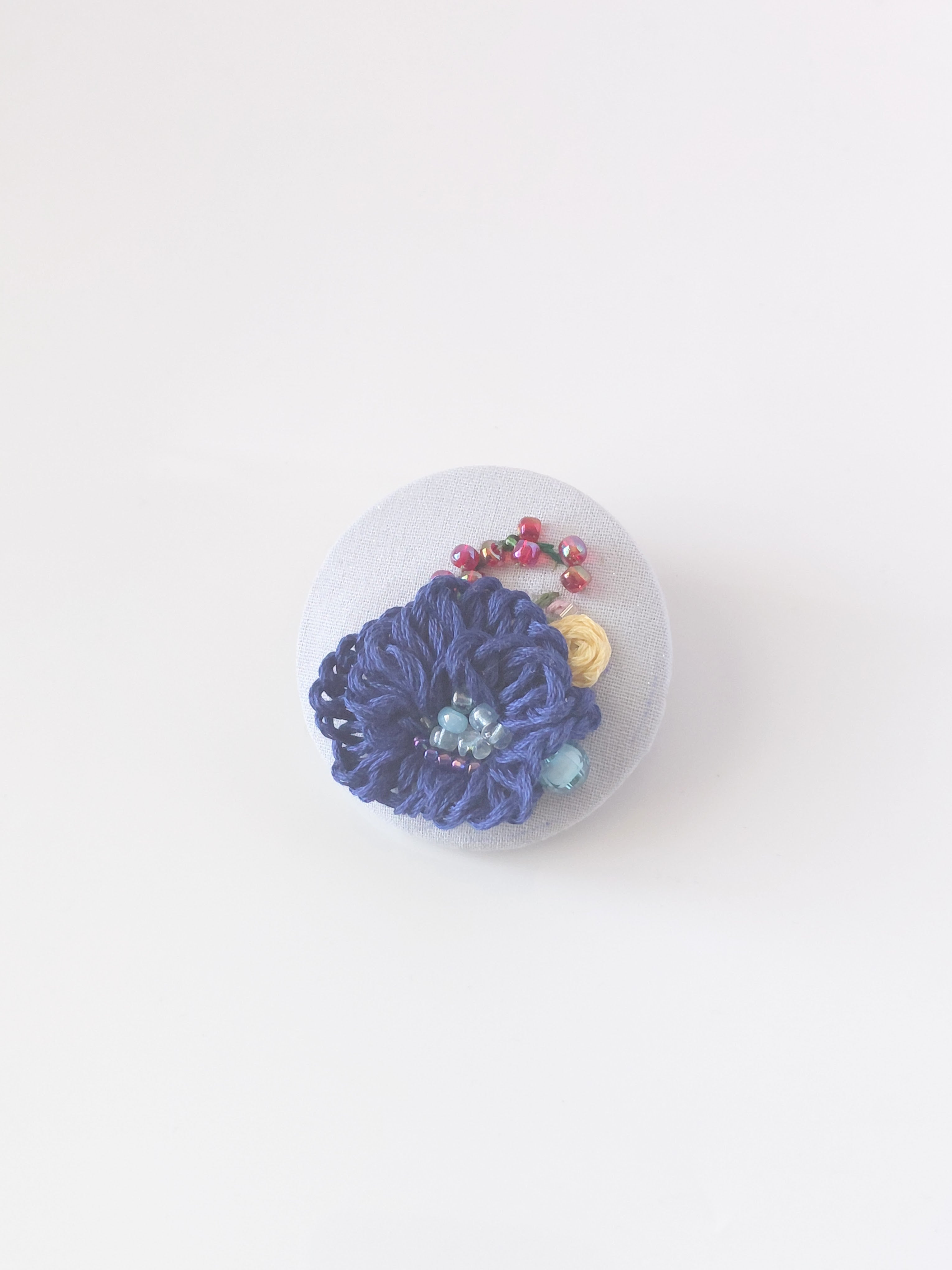 Decorative blue flower brooch on grey background