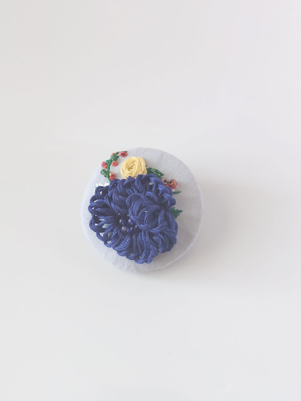 Decorative blue flower brooch on grey background