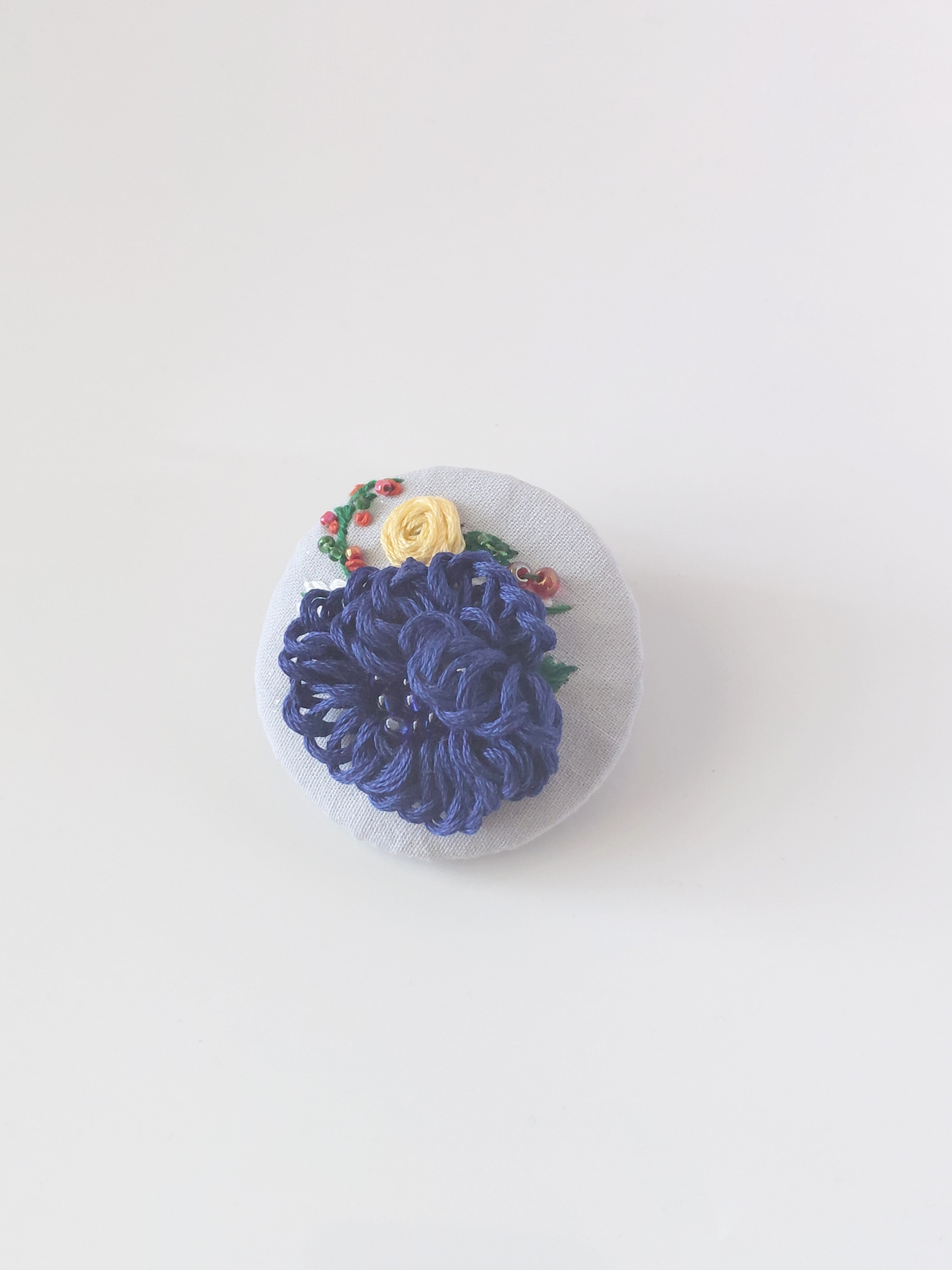Decorative blue flower brooch on grey background