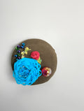 Decorative turquoise flower brooch on olive background