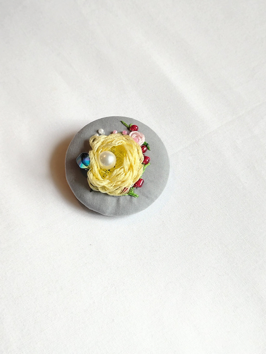 Decorative yellow flower brooch on grey background