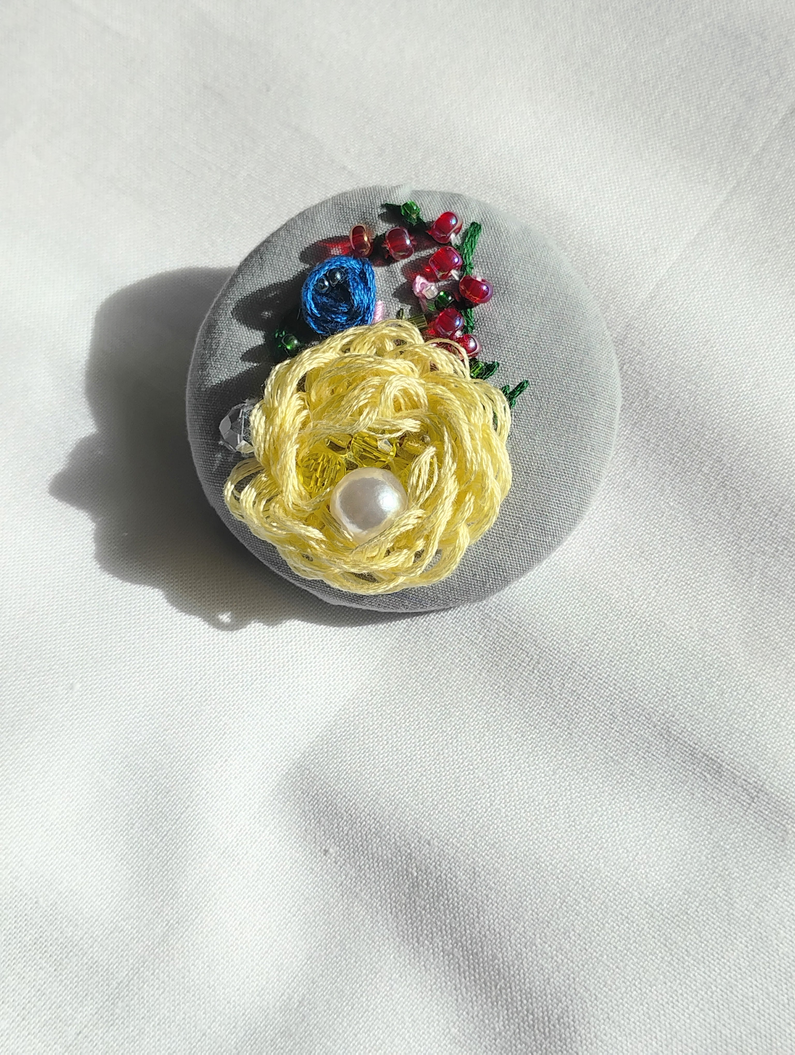 Decorative yellow flower brooch on grey background