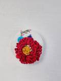 Decorative burgundy flower brooch on white background
