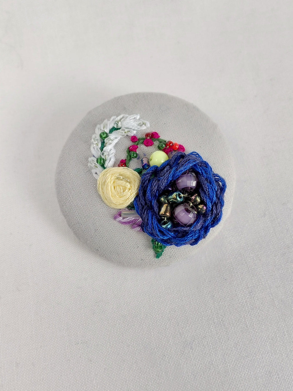 Decorative blue flower brooch on grey with specs background
