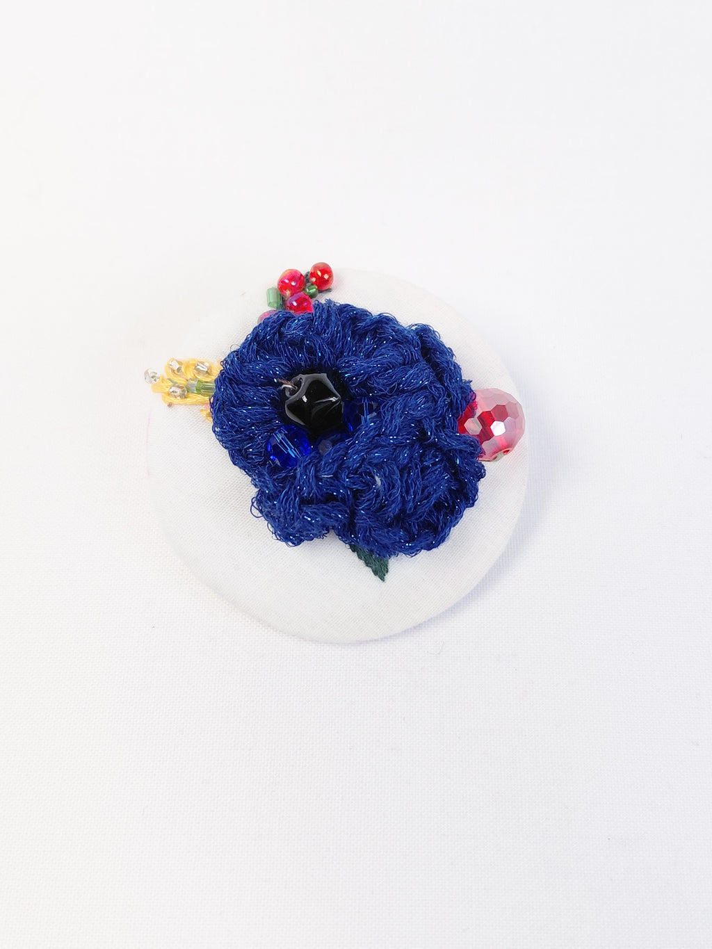 Decorative blue flower brooch on white background