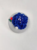 Decorative blue flower brooch on grey background