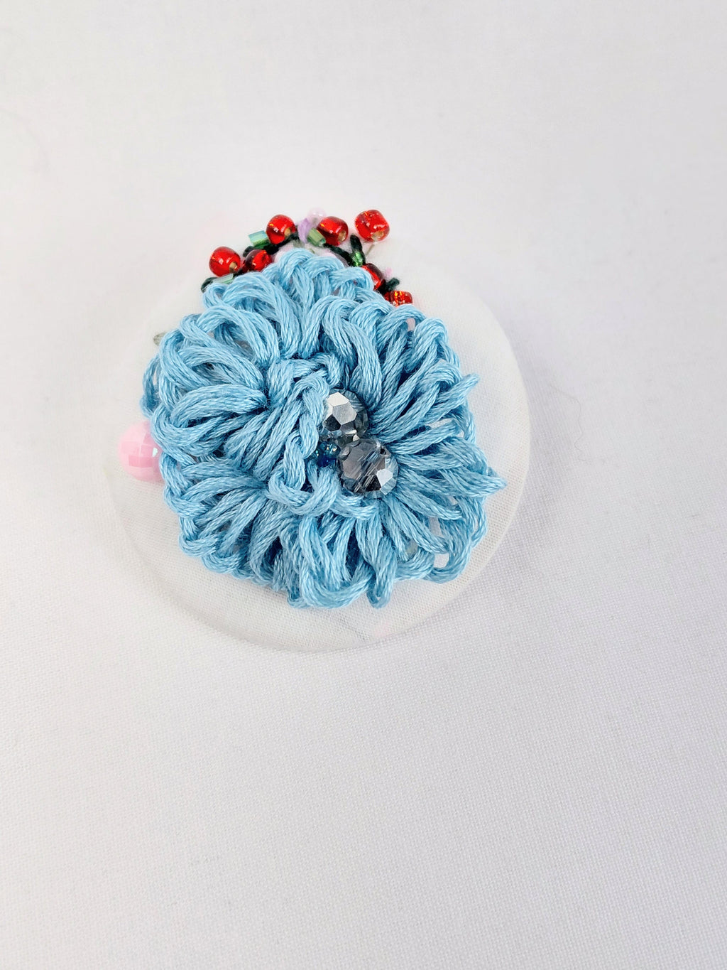 Decorative blue flower brooch on white background