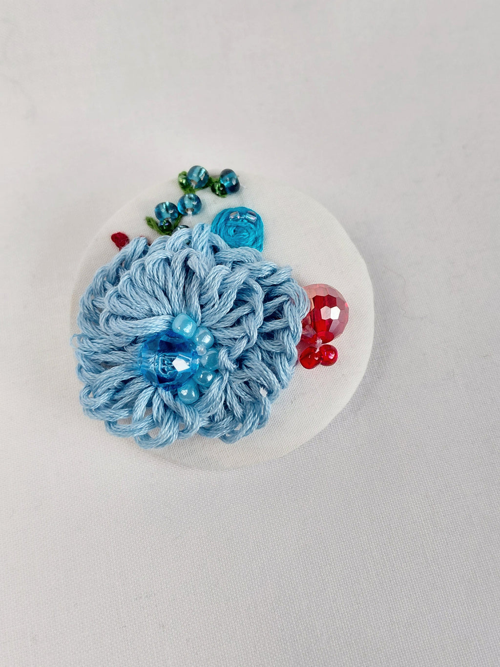 Decorative blue flower brooch on white background