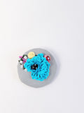 Decorative turquoise flower brooch on grey   background