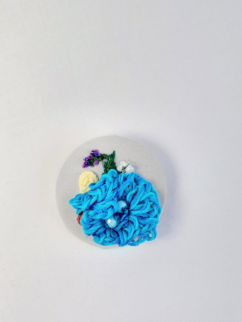 Decorative turquoise flower brooch on grey with specs background