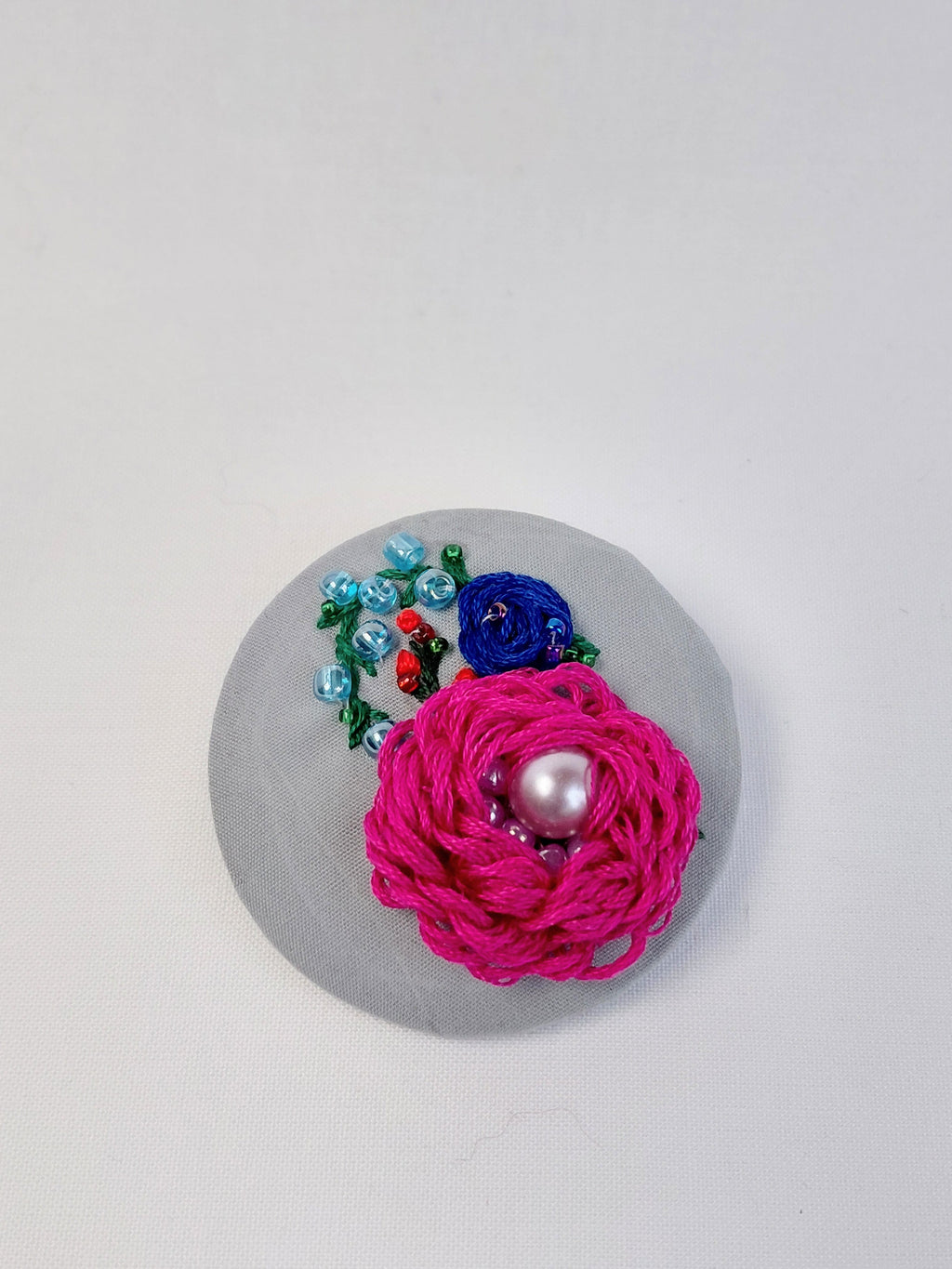 Decorative fuschia flower brooch on grey  background