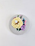 Decorative yellow flower brooch on grey with specs background