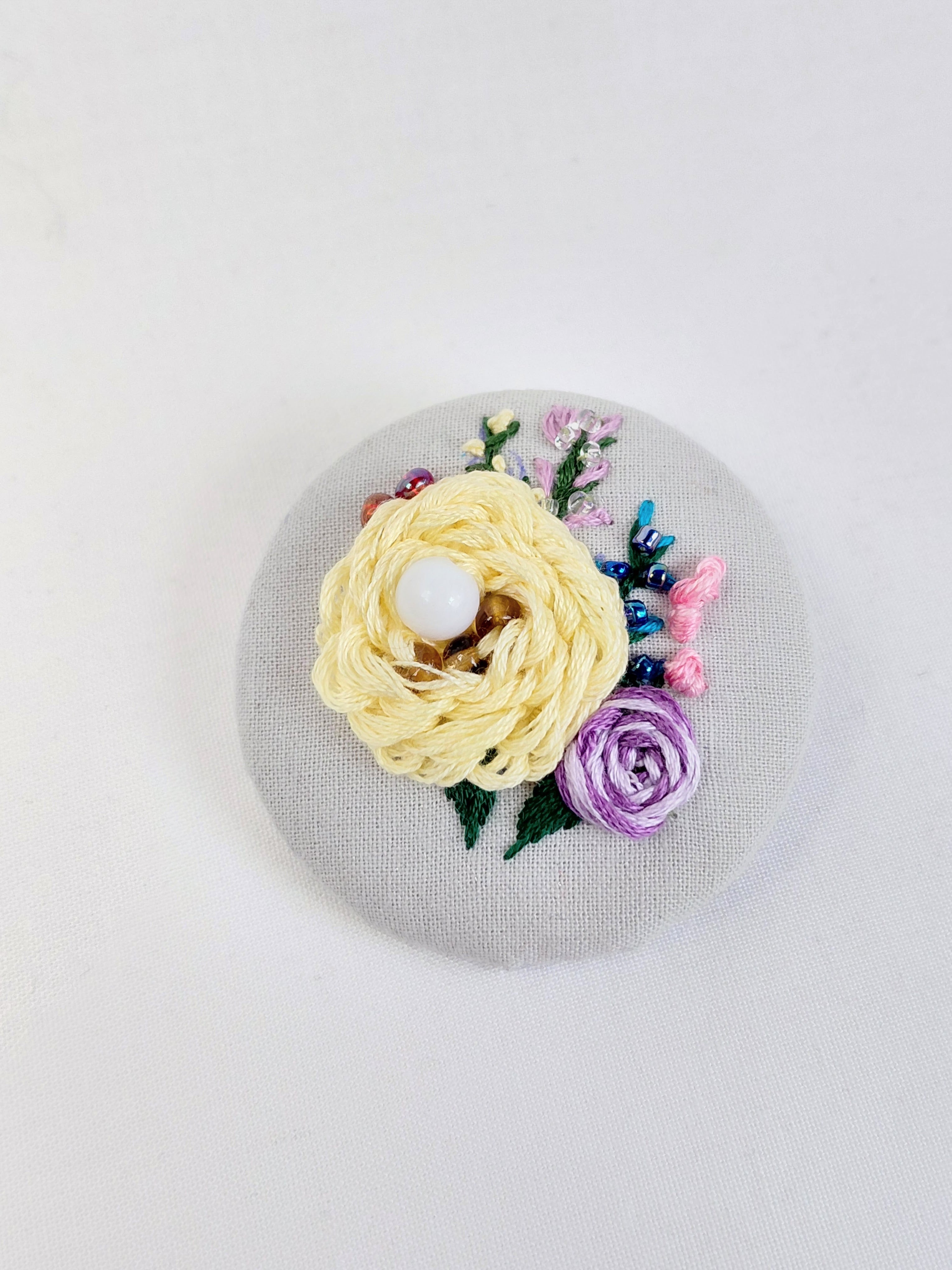 Decorative yellow flower brooch on grey with specs background