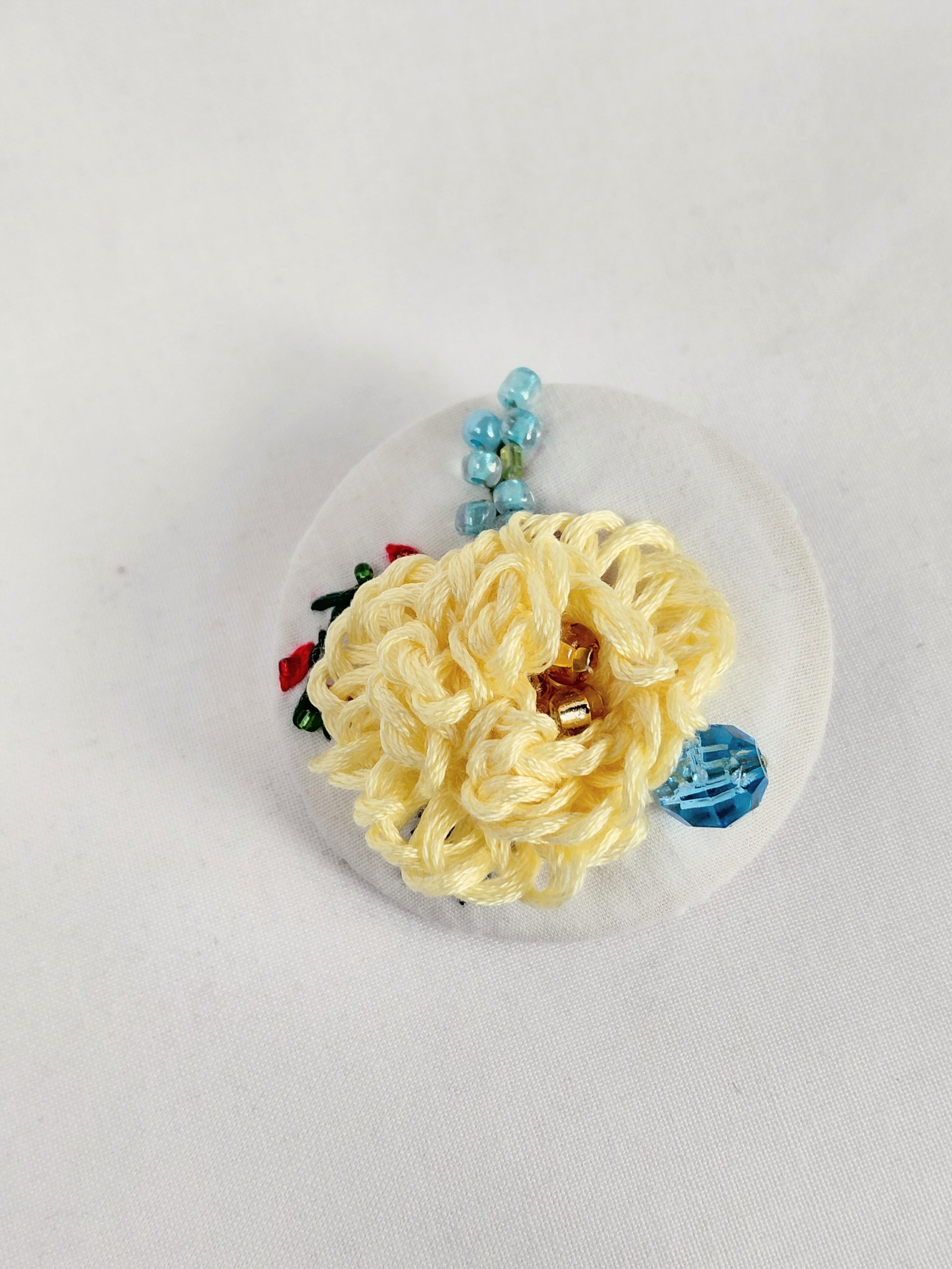Decorative yellow flower brooch on white background