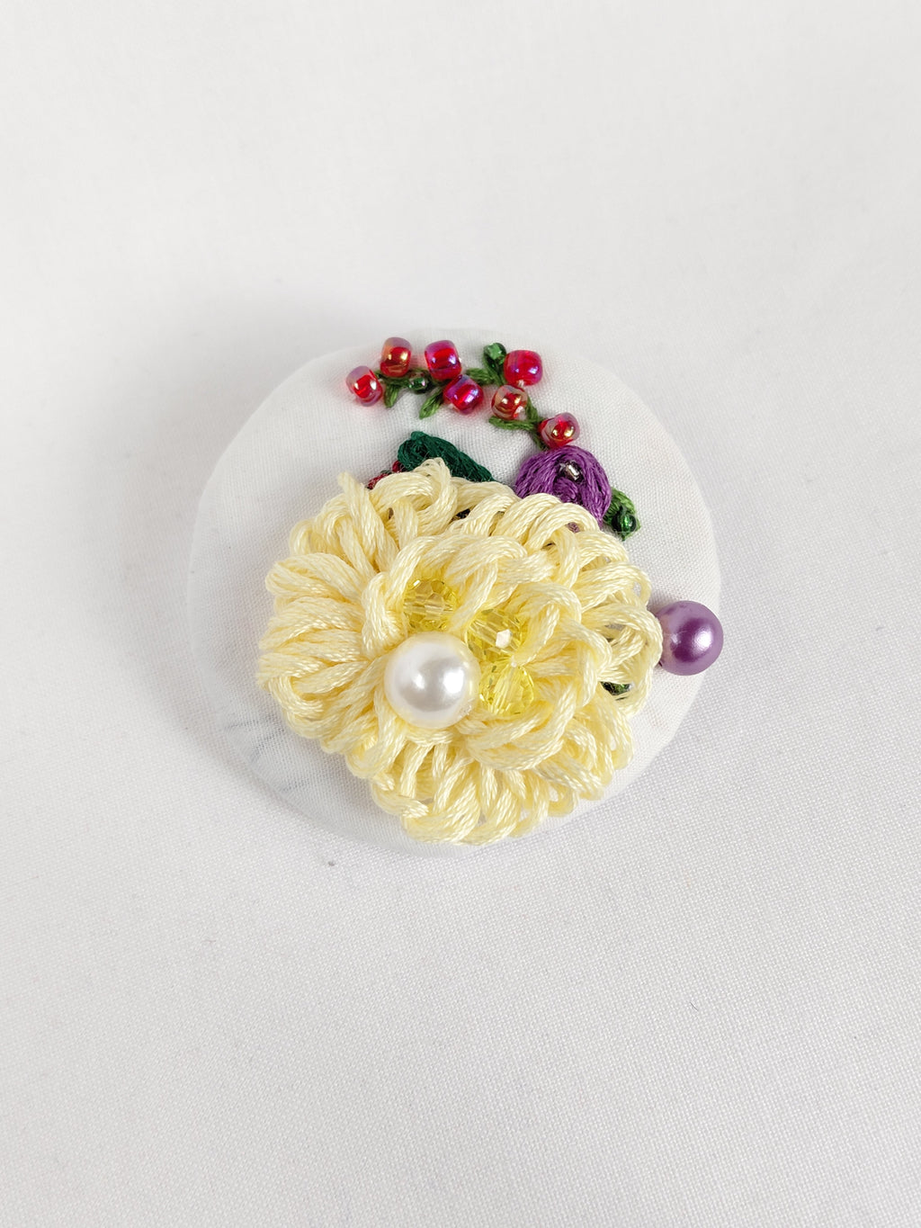 Decorative yellow flower brooch on white background