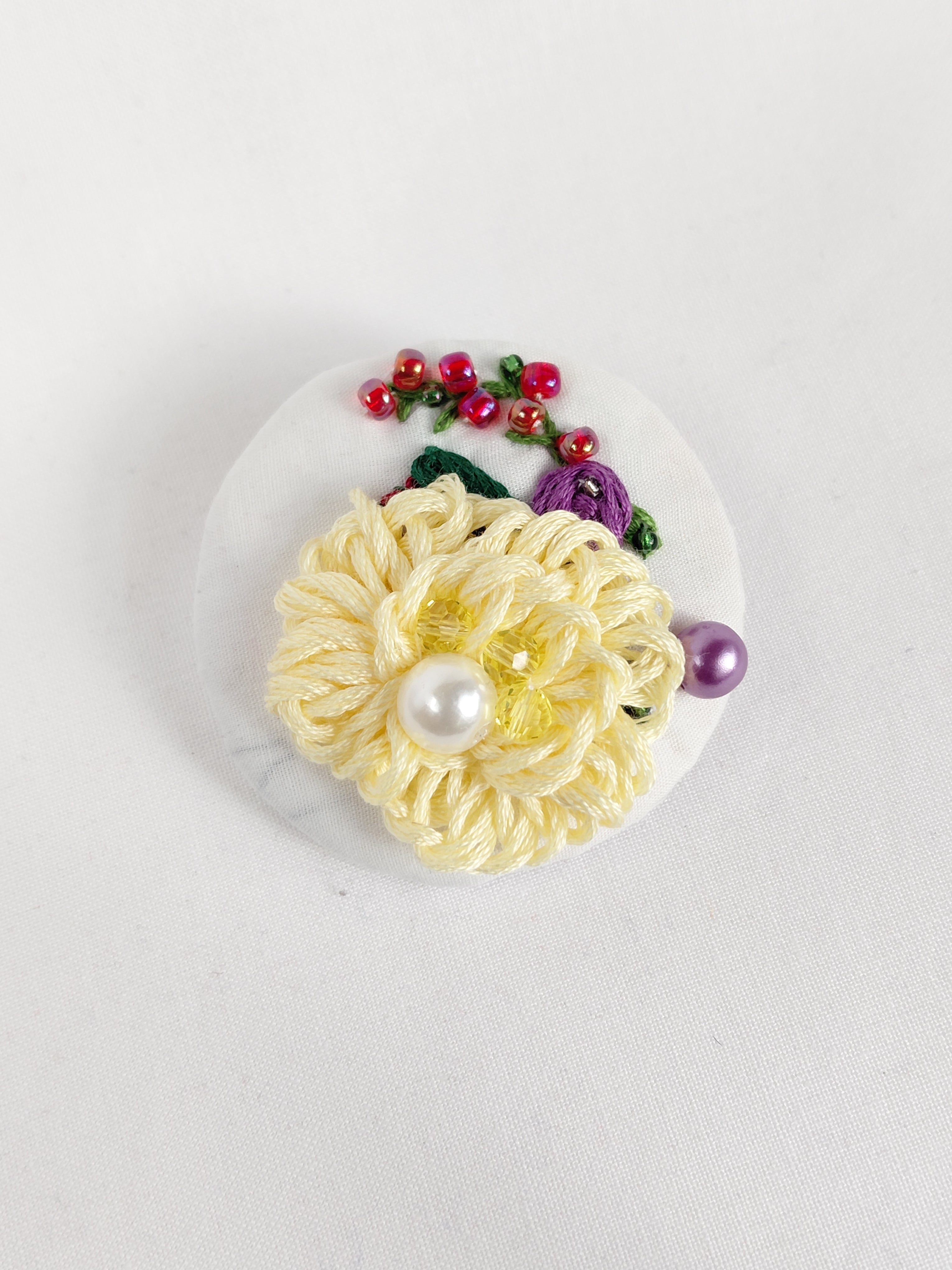 Decorative yellow flower brooch on white background