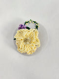 Decorative yellow flower brooch on grey with specs background