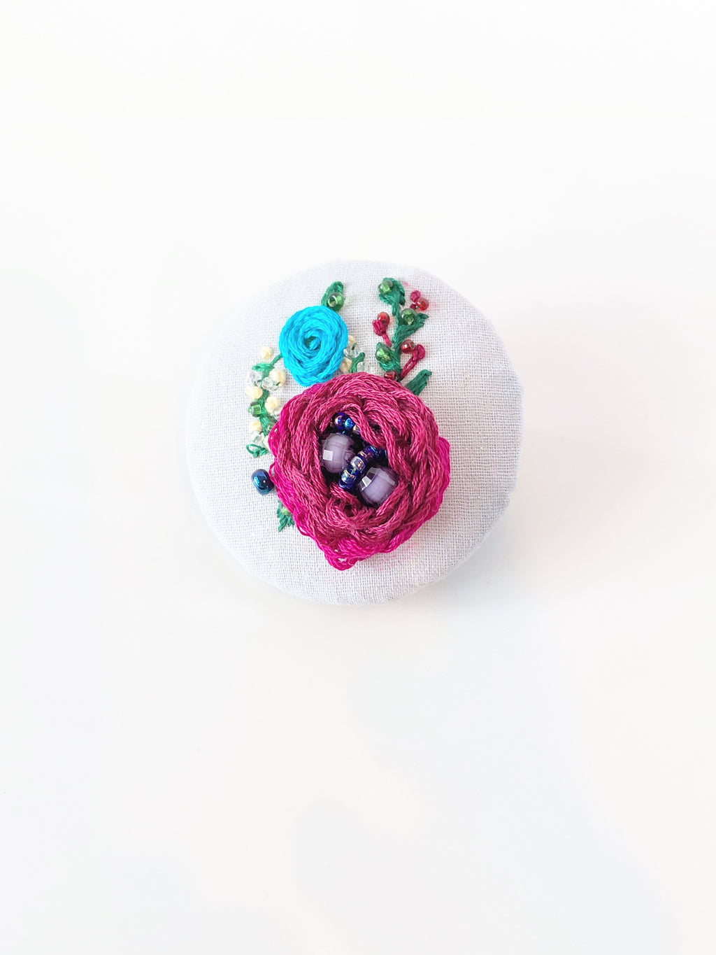 Decorative burgundy flower brooch on grey background