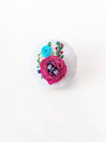 Decorative burgundy flower brooch on grey background