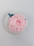 Decorative pink flower brooch on white background