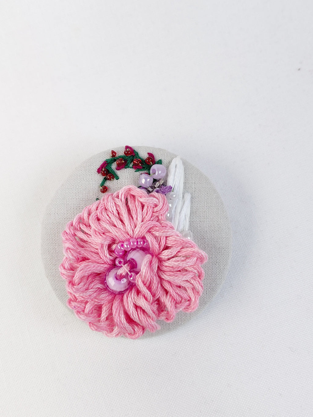 Decorative pink flower brooch on grey with specs background