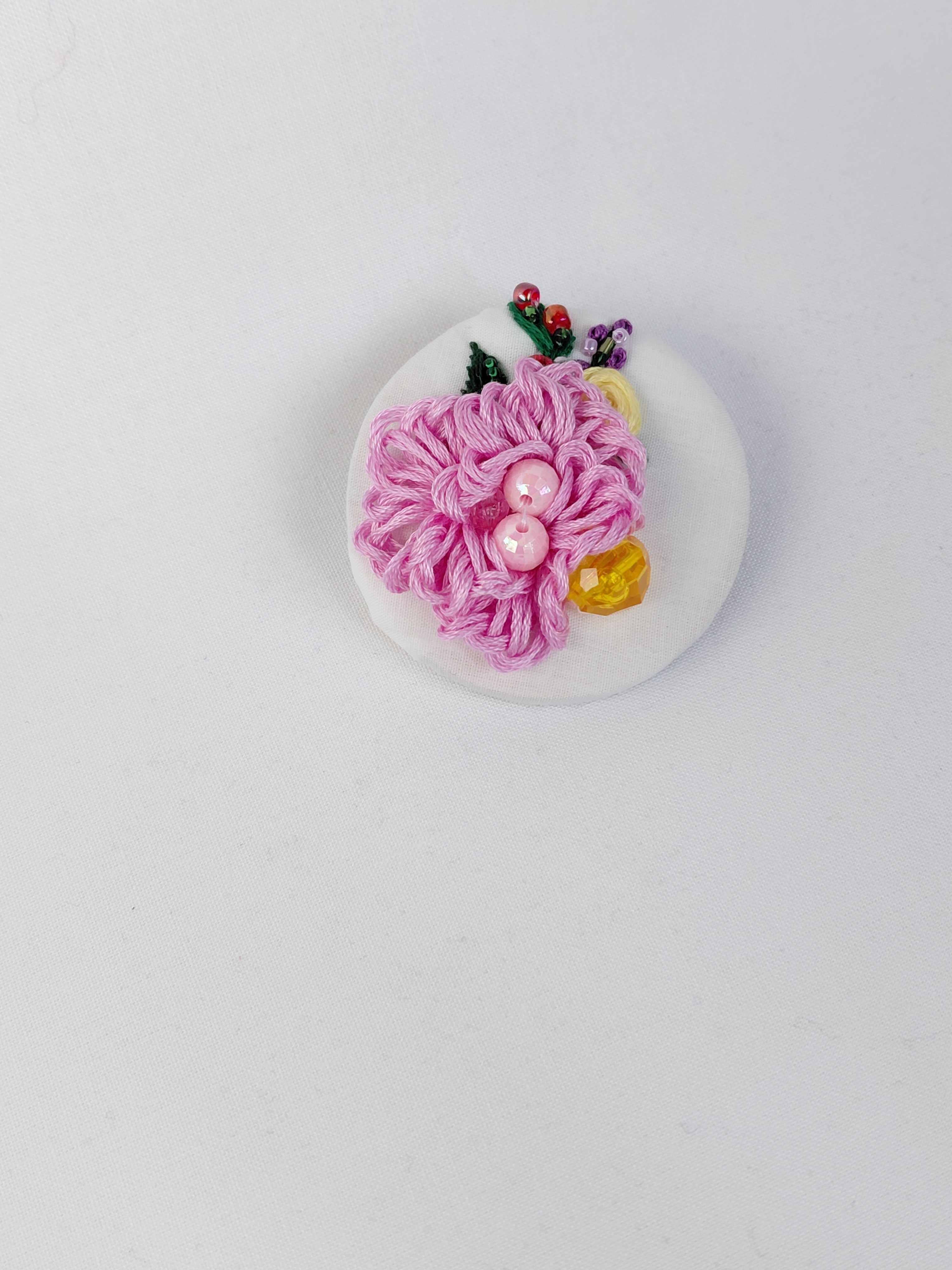 Decorative pink flower brooch on white background