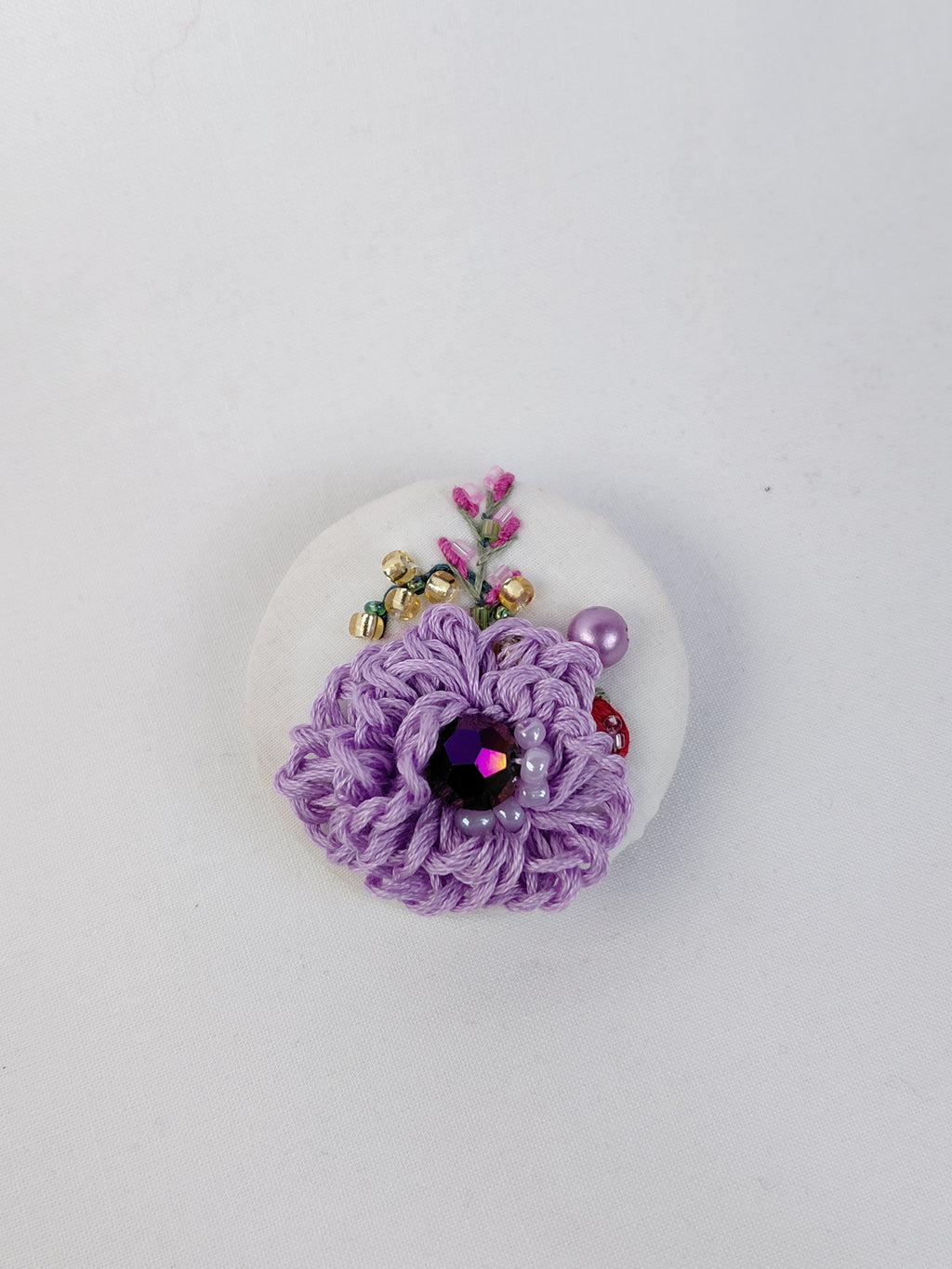 Decorative purple flower brooch on white background