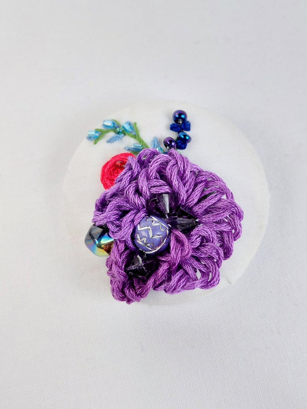Decorative purple flower brooch on white background