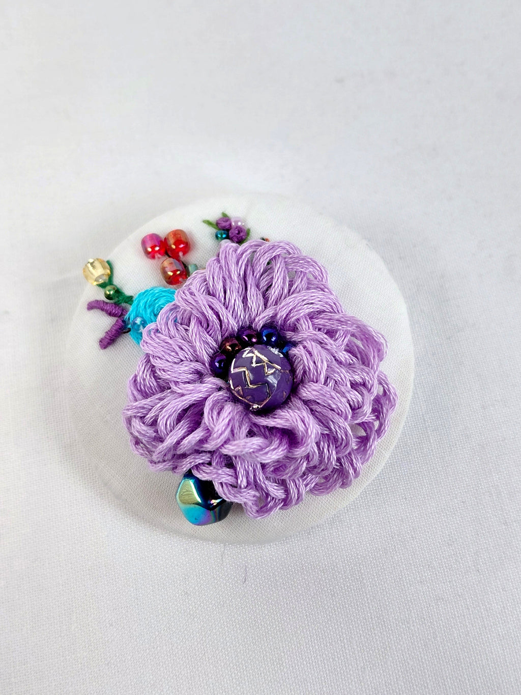 Decorative purple flower brooch on white background
